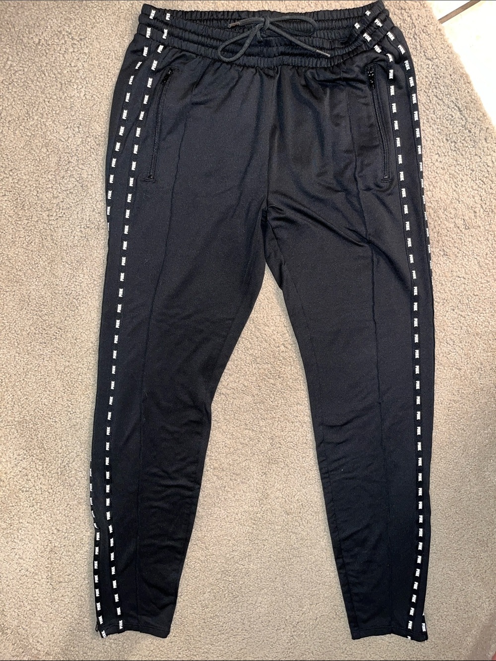 Women’s Black Track Pants with Side pipings that say PINK